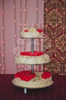 Three-tiered cake with white swans and roses.
