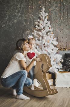 Embrace mother and child on the background of Christmas decorations.