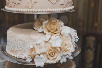 Wedding cake decorated with beige flowers from the cream.
