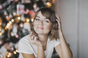 Close-up portrait of a beautiful girl on the background of Christmas lights.