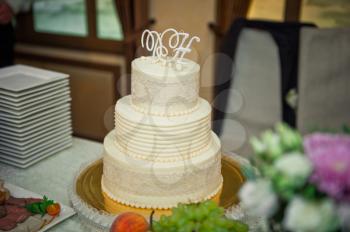 Three-tiered white-and-beige cake for the wedding.