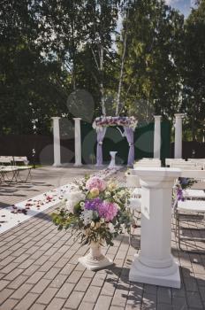 Vases and pedestals with flowers.