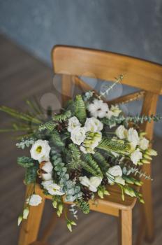 A bouquet of flowers on a little chair.