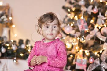 Portrait of a child on the Christmas sparkling lights of the Christmas tree.
