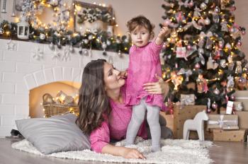 Portrait of baby and his mum in the Studio with Christmas decorations.