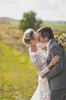 Portrait of young beautiful couple kissing on the background of the wide field.