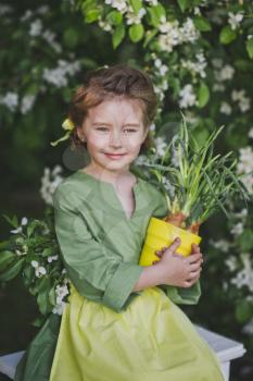 The child holds a tub of sprouted leek.