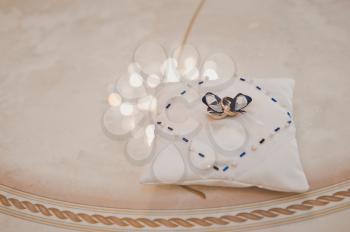 Wedding rings on a fabric pillow.