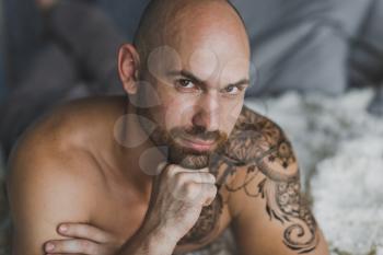 Close-up portrait of a bald brutal man with a beard.