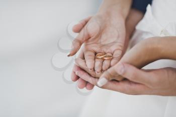 Arms of hands of Bridal couple with wedding rings.