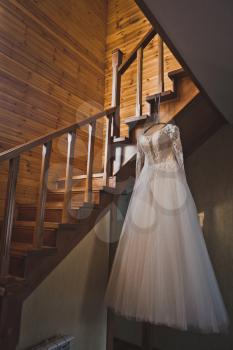 Wedding dress on the steps of a wooden staircase.