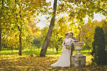 Portrait of newlyweds in autumn garden.