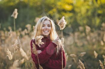 The girl smiles happily among the reeds.