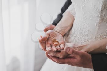 The gentle embrace of your hands wearing wedding rings.