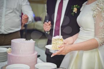 The couple cut a wedding cake for a tea party with the guests.