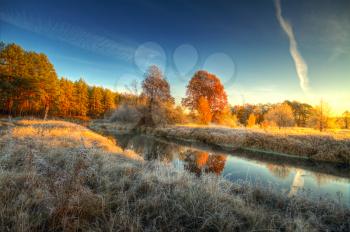 Dawn at the river .osen. frost on trees and grass