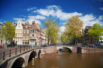 Beautiful view of Amsterdam canals with bridge and typical dutch houses. Holland