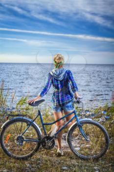 girl on a bicycle near the sea. Photo-style pin-up