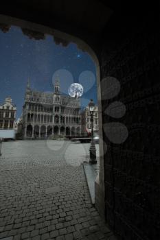 Grand Place - the historic square in the center of Brussels. Town Hall and the Bread House, or House of the King. moon and the stars shine in the night sky.