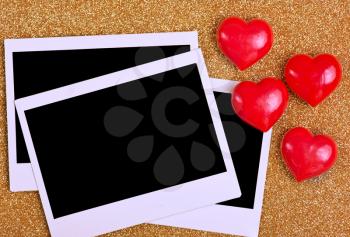Blank instant photo and hearts on a table