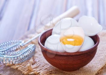raw eggs in bowl and on a table