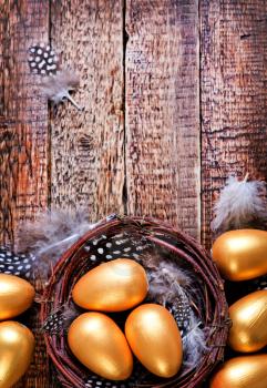 golden eggs in nest and on a table