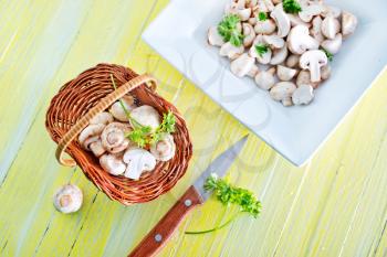 raw mushrooms in basket and on a table