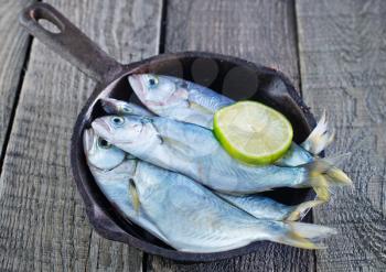 raw fish with lemon on the pan and on a table