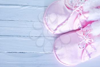 pink baby shoes on the wooden table