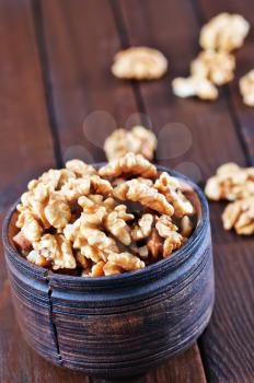 walnuts in wooden bowl and on a table