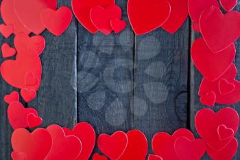 red hearts from paper on the wooden board