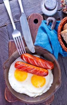 breakfast on a table, fried eggs with sausages