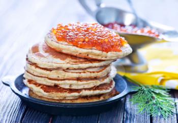 pancakes with red salmon caviar on plate