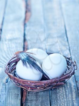 chicken eggs in the nest and on a table