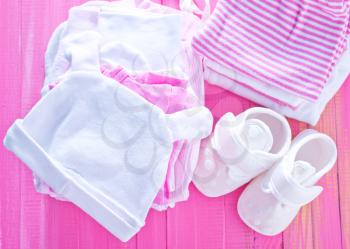 baby clothes on the pink table, stack of baby clothes