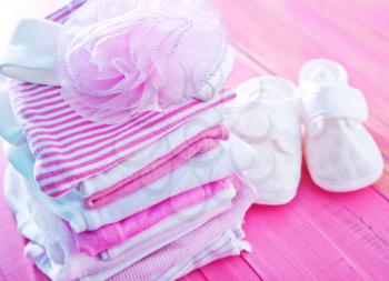 baby clothes on the pink table, stack of baby clothes
