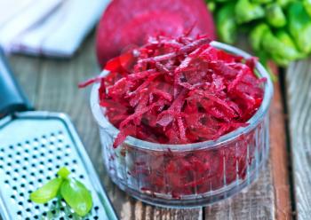 grated beet in bowl and on a table