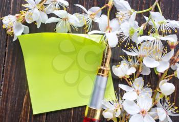 flowers and paper on wooden background
