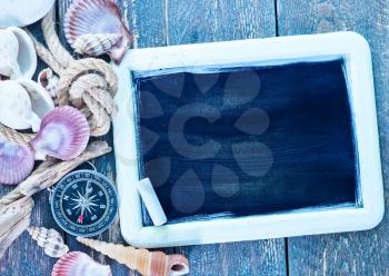 background, sea shells and compass on a table