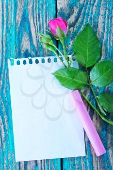 rose and note on the wooden table