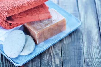 soap, stones and towels on the wooden plate