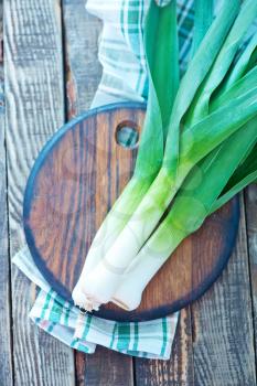 fresh leek on wooden board and on a table