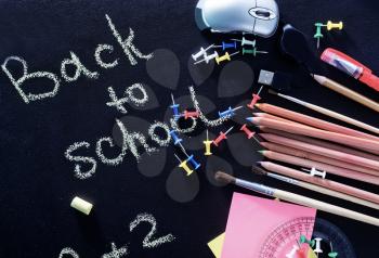 school supplies on the black board, color pencils and sheets