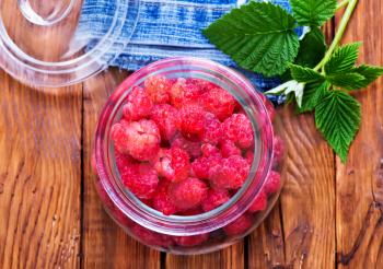 fresh raspberry in glass bank and on a table