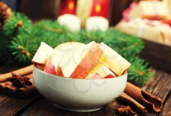 apples with cinnamon in the bowl and on a table