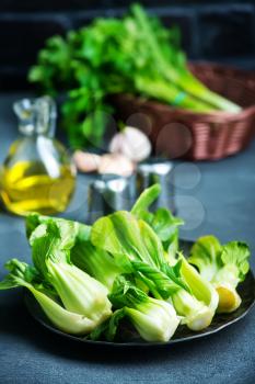 fresh pak choi on plate and on a table