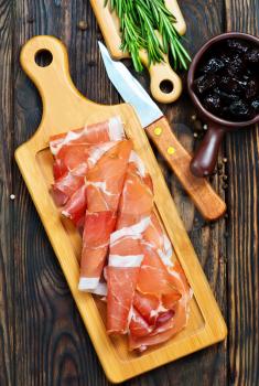 Slices of tasty spanish ham on board 