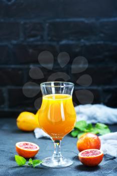 fresh oranges and juice in glass on a table