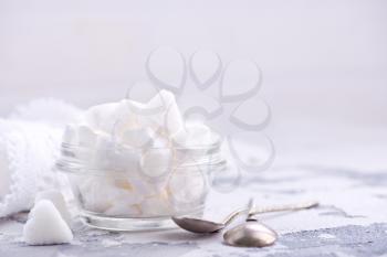 white sugar in glass bowl and on a table