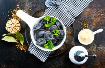 Creative dumplings from black dough, boiled pelmeni
